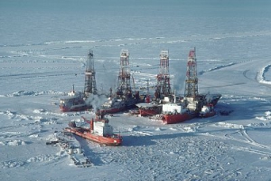 April 1980, Northwest Territories, Canada --- Oil drilling ships with towers frozen in the pack ice covering on the Beaufort Sea with an icebreaker nearby, Northwest Territories, Canada. --- Image by © Lowell Georgia/CORBIS